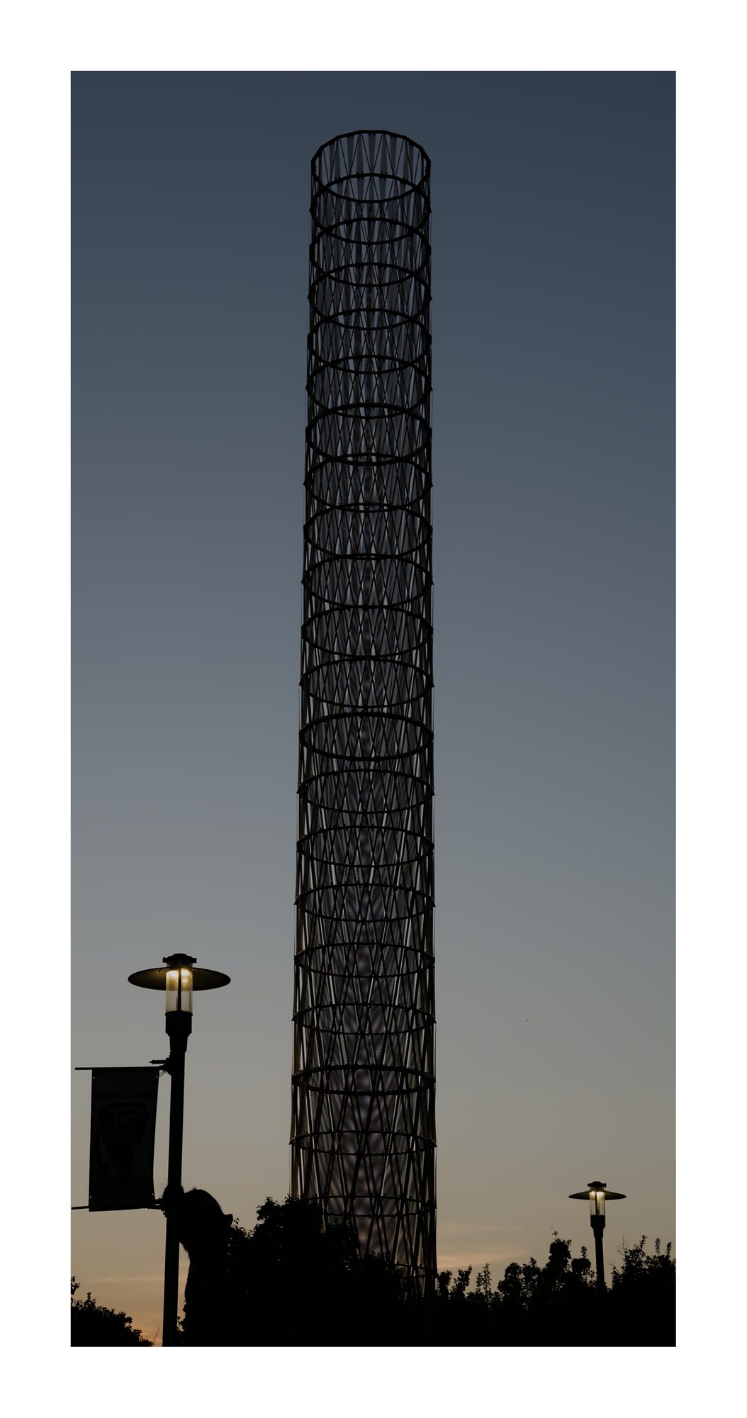 A narrow tower silhouette against evening sky.