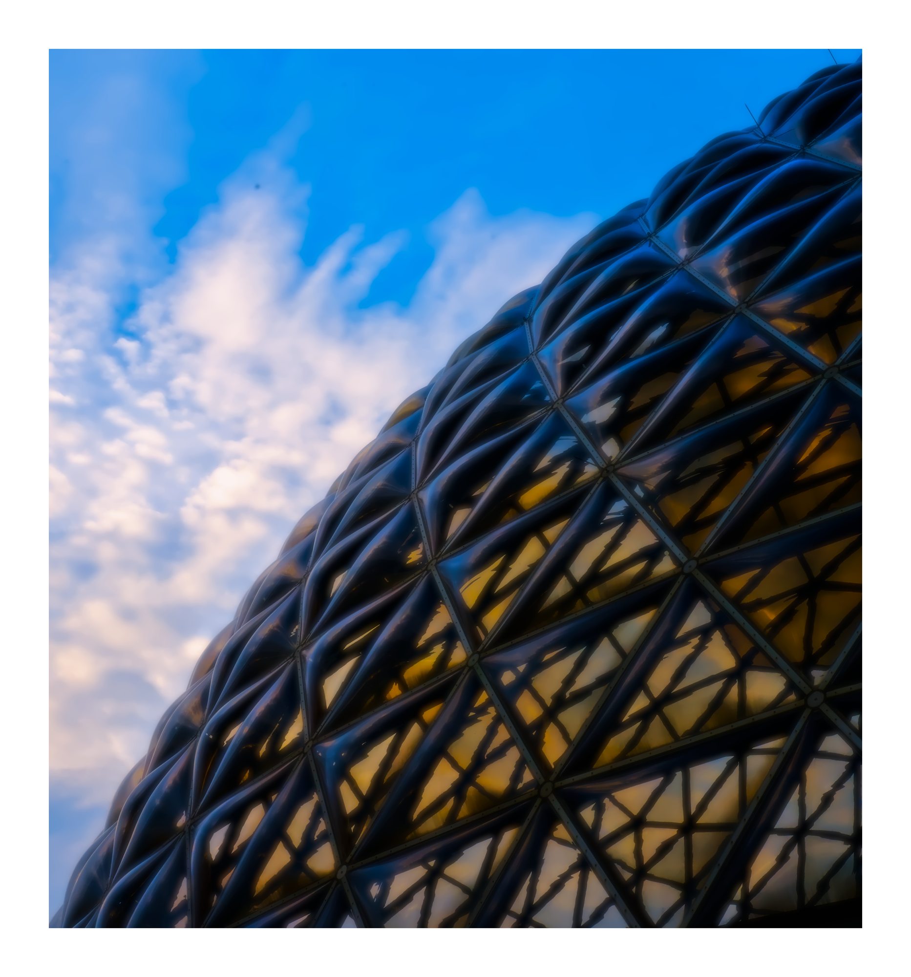 A close view of a tall metal structure against blue sky.