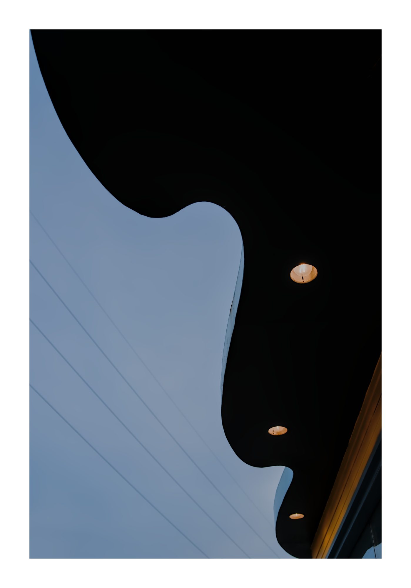 Dark curved roof detail with small lights.