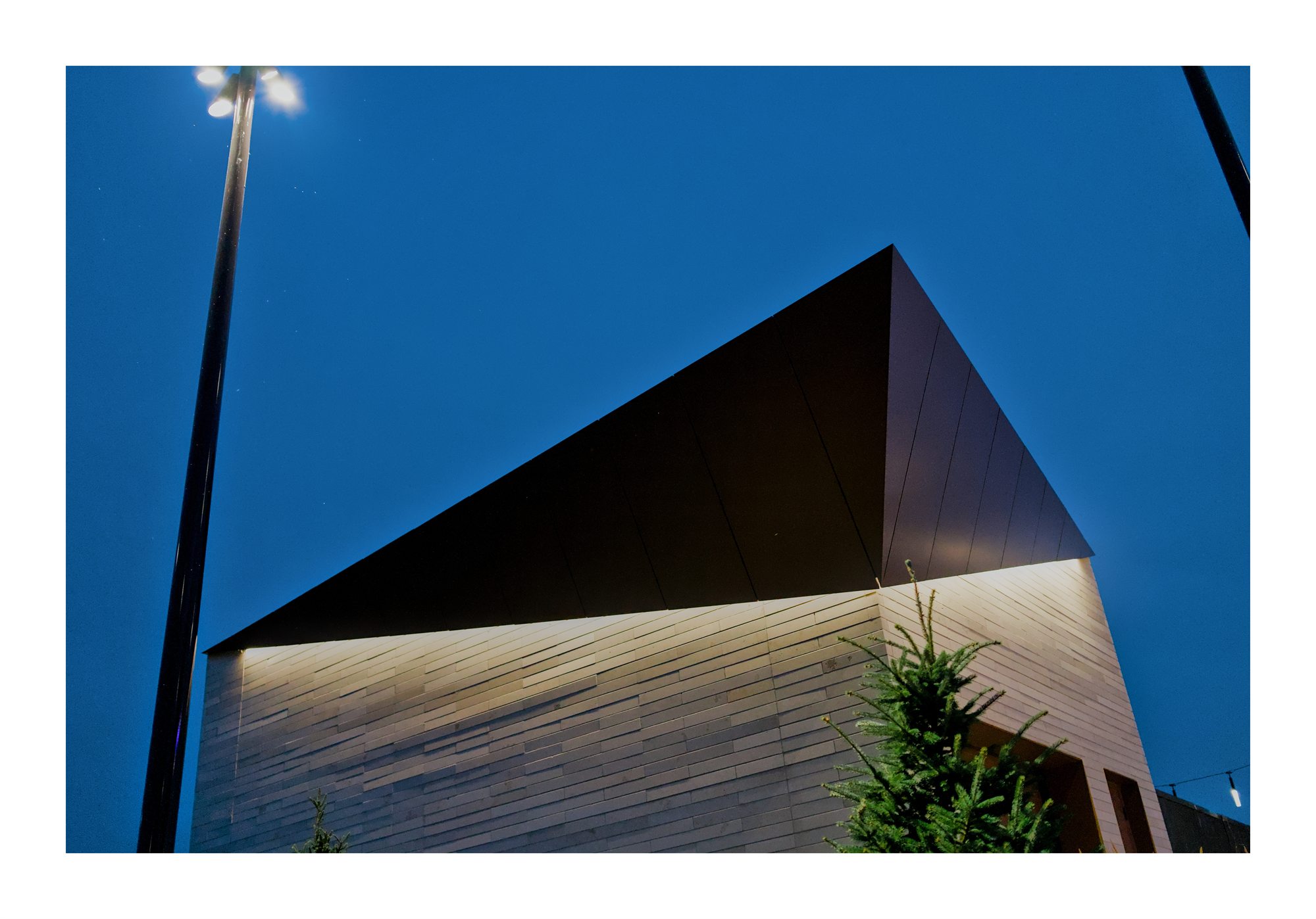 A white angular building facade against deep blue sky.