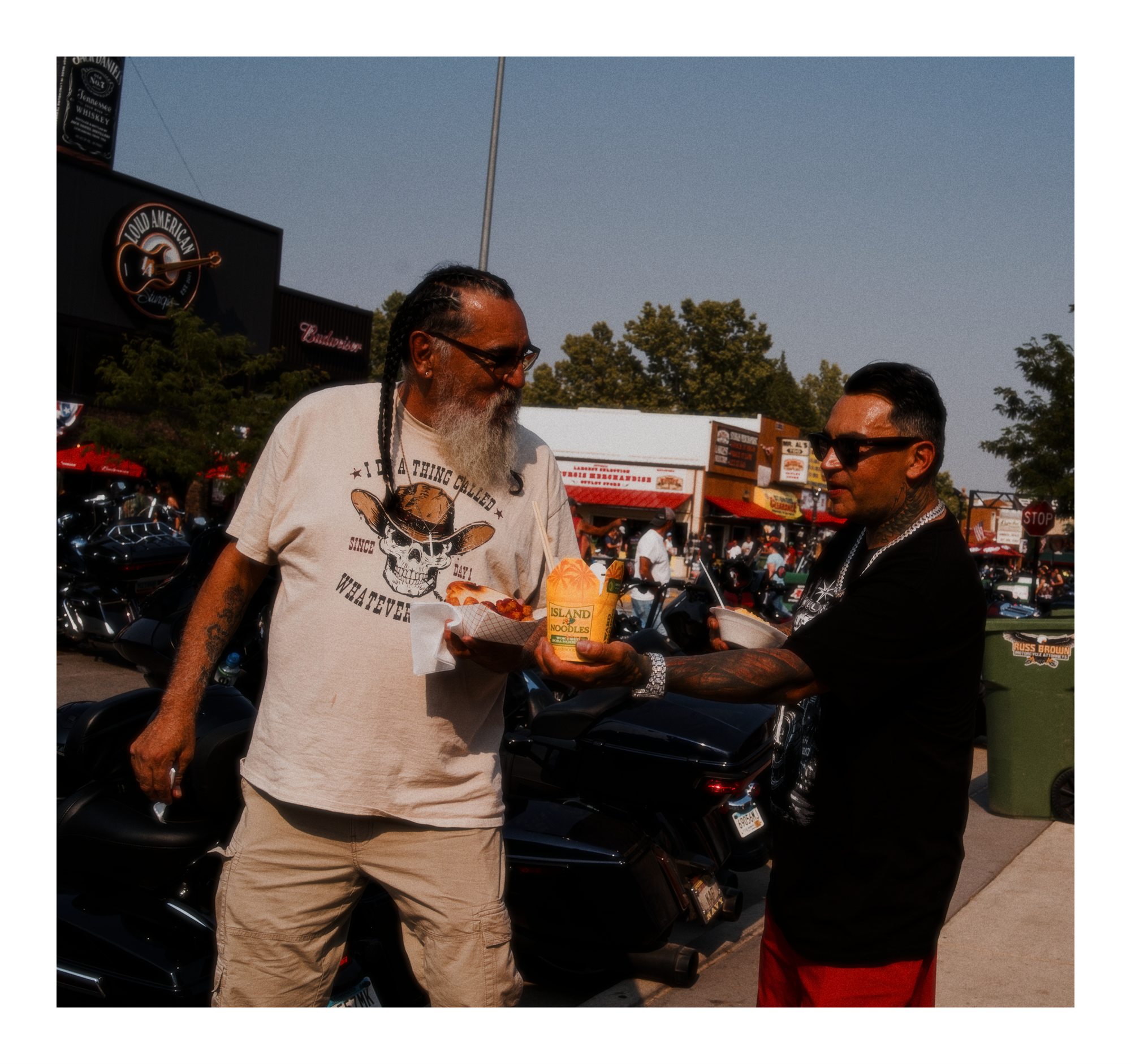 Two men talking beside motorcycles at the rally.