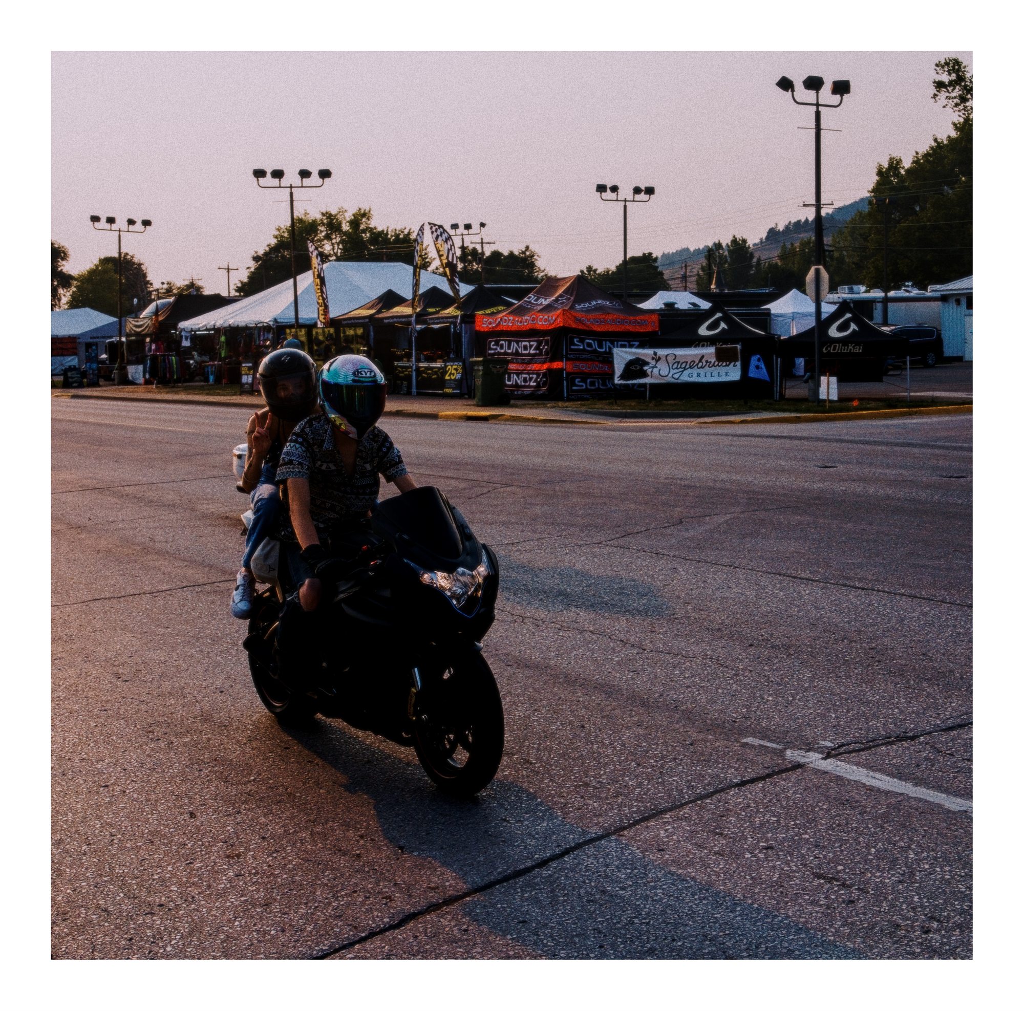 A motorcyclist riding through warm evening light at the rally.